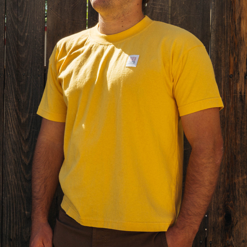 Front lifestyle image of Topo Designs x Soft Goods Label Tee in "Spectra Yellow"