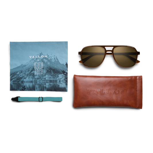 General view of VALLON X Topo Designs sunglasses in "Brown / Brown" with microfiber cloth, leather sunglasses case, and sunglasses strap.
