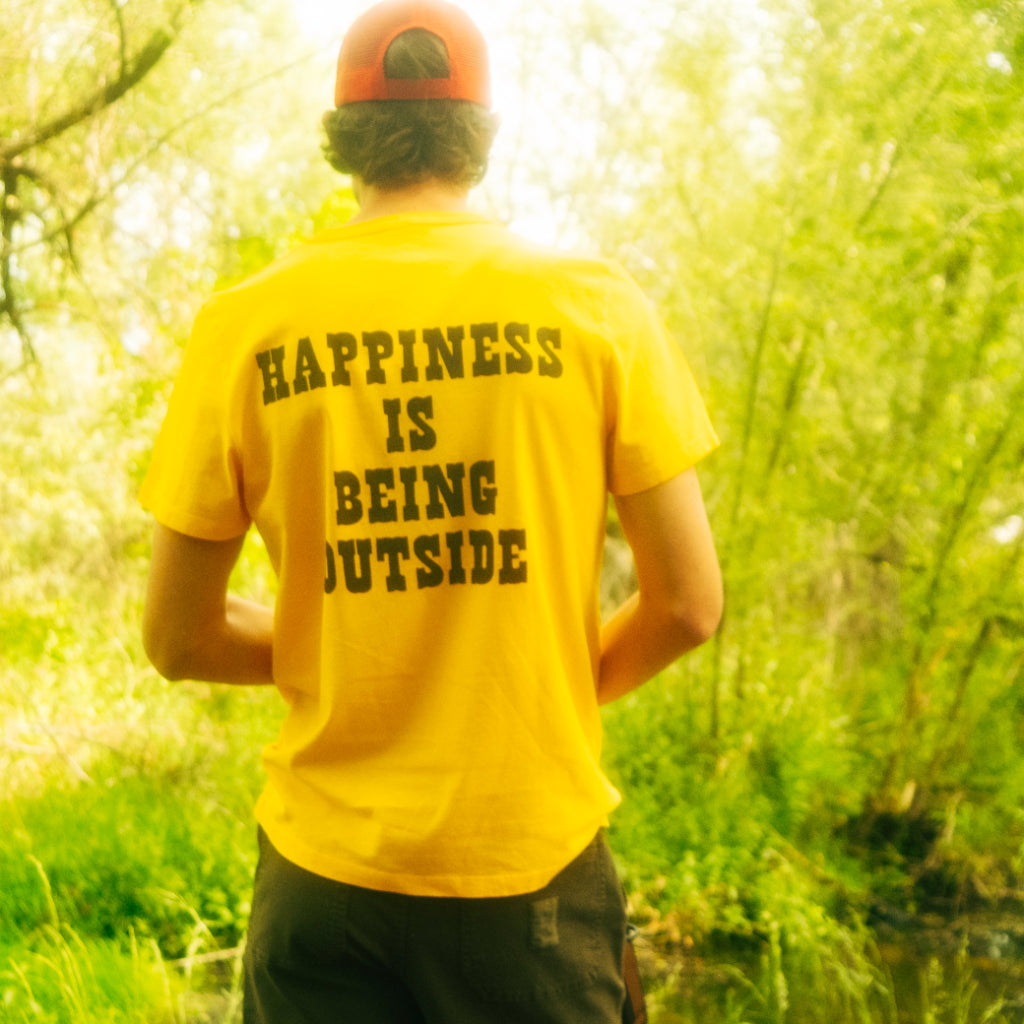 General lifestyle image of Topo Designs x TSPTR Being Outside Tee in "Yellow"