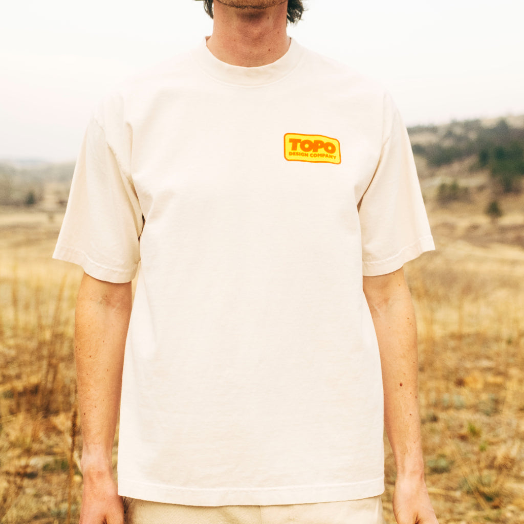 General front model image of Topo Designs x Pine Printshop Catalog Tee in "Creme"
